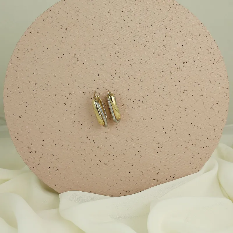 Aros de oro rectangulares sobre un soporte de cerámica
